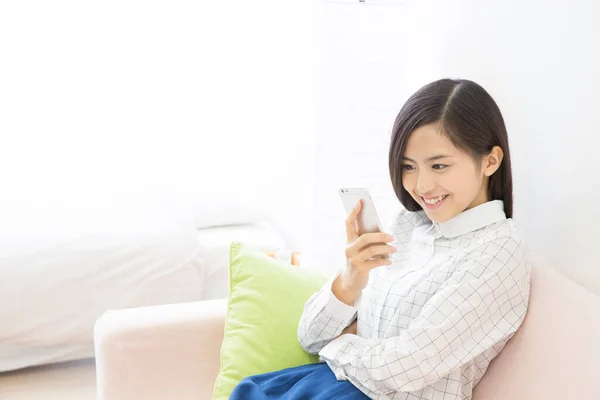 Νεαρή Ασιάτισσα Γυναίκα Που Χρησιμοποιεί Smartphone Στο Σπίτι — Φωτογραφία Αρχείου