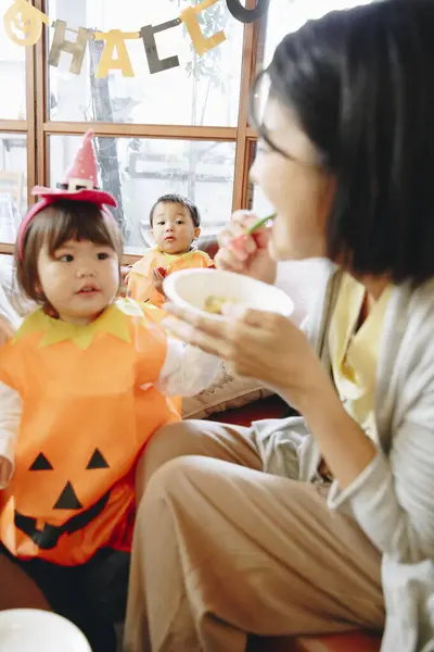 自宅でハロウィーンを祝う子供を持つ日本人女性 — ストック写真