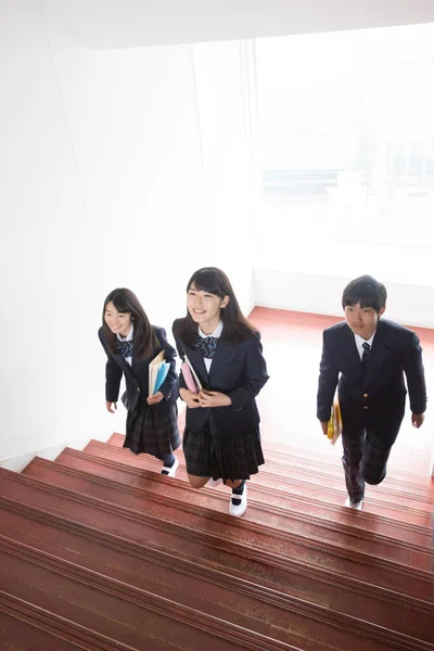 Jóvenes Estudiantes Japoneses Alegres Con Libros Escuela Japonesa Imágenes de stock libres de derechos