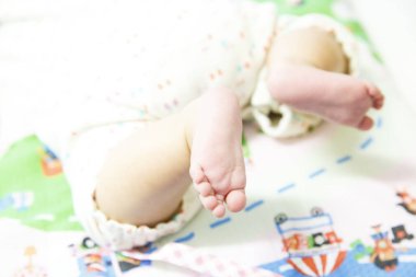 Bebek ayakları renkli battaniyede dinleniyor.