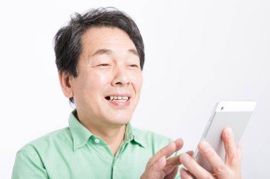 Tablet kampçısı kullanan kıdemli Asyalı adam. 