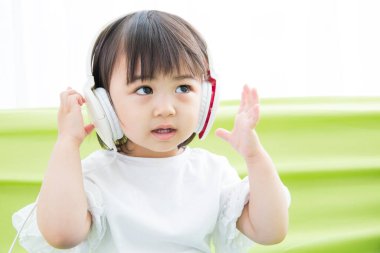 Kulaklık dinleyen Asyalı şirin bir çocuk.