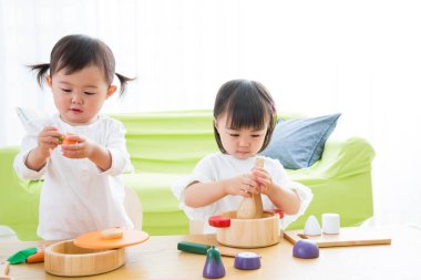 Tahta oyuncaklarla oynayan iki genç kız.