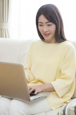 Bilgisayarda çalışan Asyalı kadını kapatın.