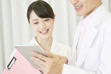 Genç Asyalı hemşire ve doktor hastane koğuşunda.