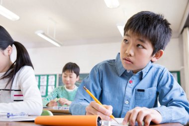 Asyalı okul çocukları sınıfta okuyor.