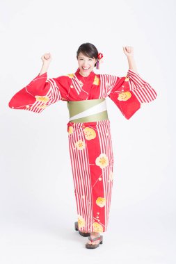 Geleneksel kırmızı kimonolu gülümseyen Asyalı kadının portresi.