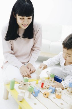 Evde annesiyle oynayan tatlı Japon çocuk.