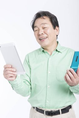 Beyaz arka planda tablet bilgisayarı ve cep telefonu olan Asyalı iş adamı.