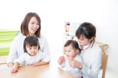 Kadınlar ve çocuklar masada oturuyor.