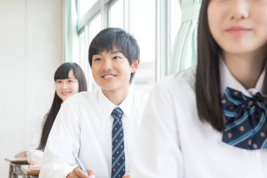 Genç Japon öğrenciler sınıfta okuyor.