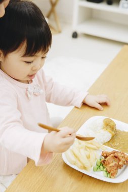 Güzel Asyalı kız evde Japon yemeği yiyor.