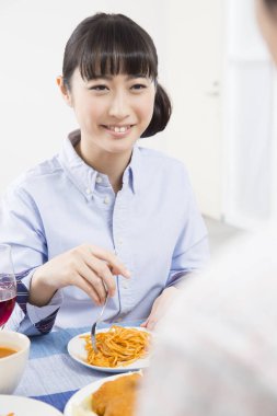 Evde erişte yiyen Asyalı kadın. 