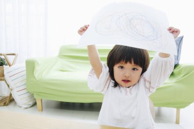 Sevimli çocuk çizimini evde tutuyor.