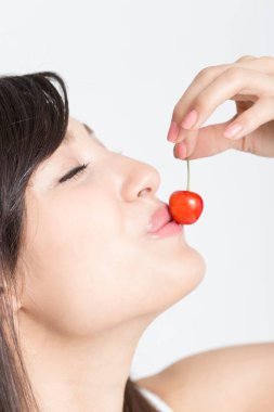 Güzel Asyalı Japon kızı yakından çek gözleri kapalı tatlı kiraz yemeye gidiyor, beyaz tenli.  