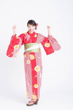 Geleneksel kırmızı kimonolu gülümseyen Asyalı kadının portresi.