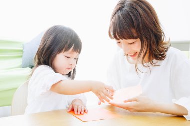 Evde annesiyle oynayan tatlı Asyalı kız.