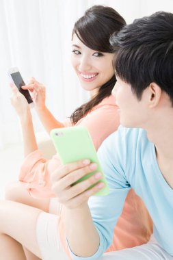 Evde cep telefonu kullanan bir çift.