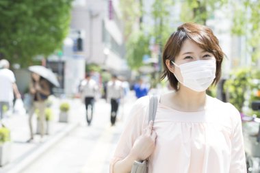 Koruyucu maskeli genç bir Japon kadının portresi.