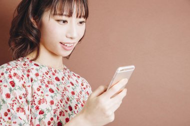 Genç Asyalı kadın cep telefonu kullanıyor.