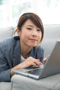 Modern ofiste dizüstü bilgisayar kullanan güzel bir Japon iş kadını.