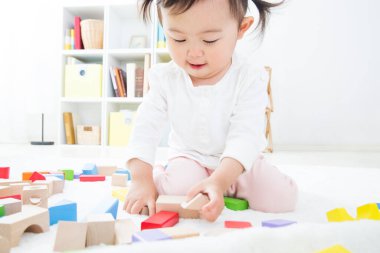 Sevimli küçük kız evde renkli küplerle oynuyor.