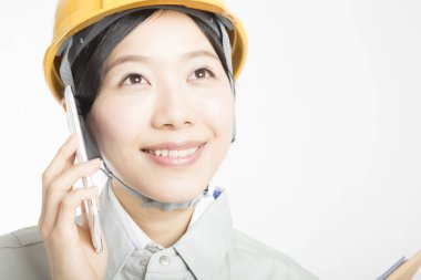 Beyaz stüdyo arka planında poz veren kasklı güzel Japon kadının portresi.