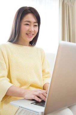 Dizüstü bilgisayarda çalışan genç bir kadın.