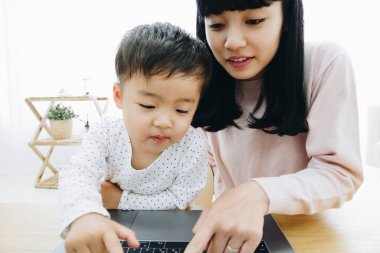 Anne ve oğul bilgisayar kullanıyor.