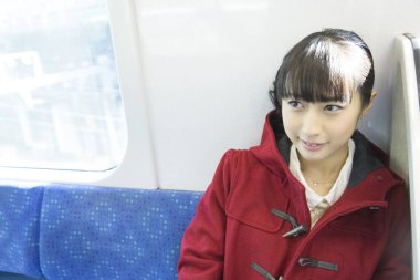 Trende oturan Japon kız.