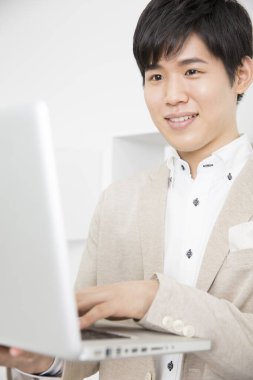 Ofiste Dizüstü bilgisayarda çalışan genç iş adamı. 