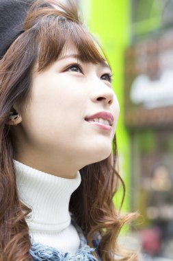 Güzel Asyalı genç kadın sokakta poz veriyor.