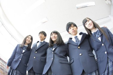 Sınıfta sarılan genç Japon öğrencilerin portresi.