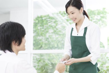 Asyalı garson müşterilerin kredi kartıyla ödeme yapıyor.