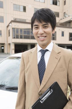 İş adamı sokakta arabasının yanında duruyor. 