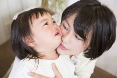 İçeride ağlayan çocuğu teselli eden kadın.