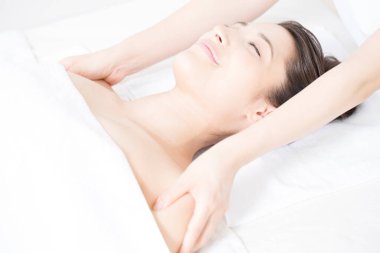 Genç bir kadın spada masaj yaptırıyor.