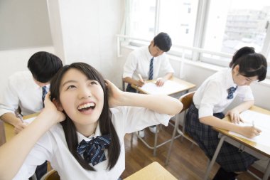 Üniformalı öğrenciler sınıfta çalışıyor.