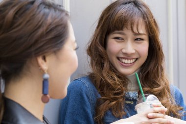 Kadın, şehirde bir arkadaşıyla içiyor. 