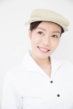 Beyaz tişörtlü, beyaz şapkalı, beyaz arka planda izole edilmiş Asyalı kadın. 