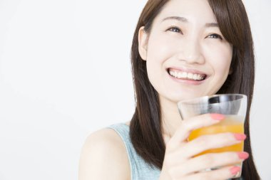 Genç bir kadın beyaz şarap içiyor.