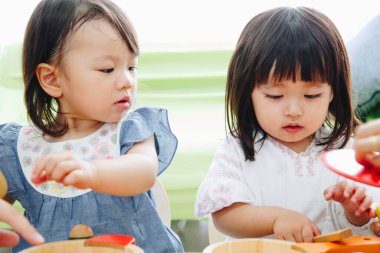 two little girls are playing on floor  at home