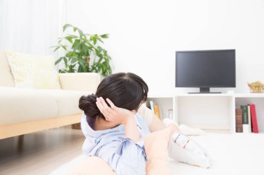 Anne ve kızı evde televizyon seyrediyor.