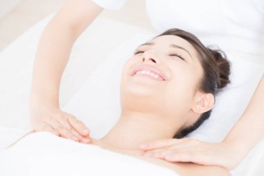 Genç bir kadın spada masaj yaptırıyor.