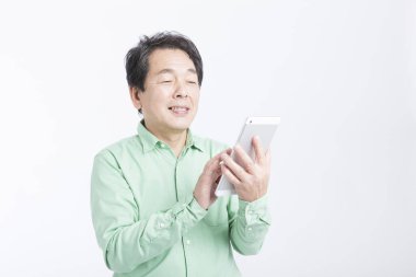 Asyalı adam beyaz arkaplanda tablet kullanıyor 