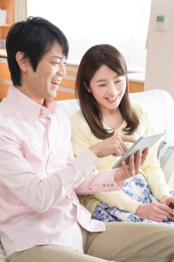 Dijital tablet kullanan genç Asyalı çift