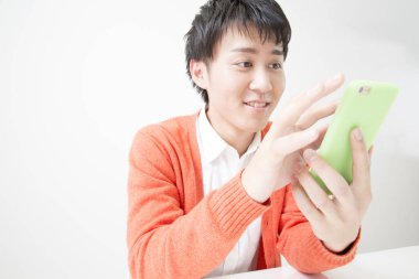 Genç adam akıllı telefon kullanıyor.