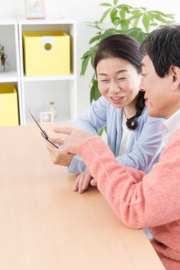 Masadaki akıllı telefona bakan yaşlı çift. 