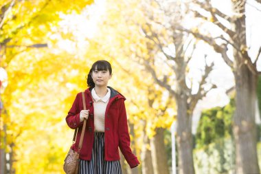 Genç Asyalı kız sonbahar parkında