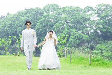 Parkta poz veren Asyalı gelin ve damat 